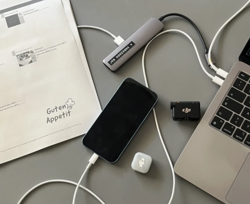 Der Aufbau für den Usability-Test: ein Smartphone, ein Laptop, ein Mikrofon und ein ausgedruckter Kita-Speiseplan auf einem Tisch